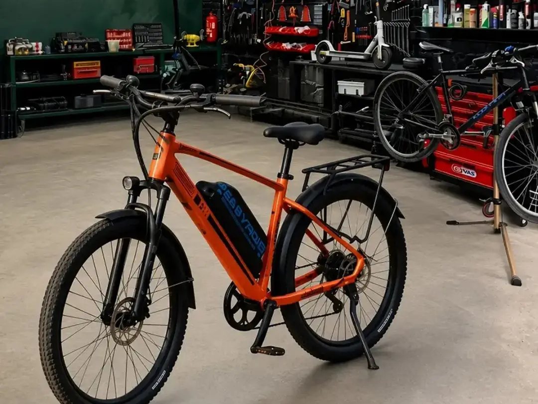 The Easyride workshop: an orange e-bike on the floor, tool wall and spare parts behind it